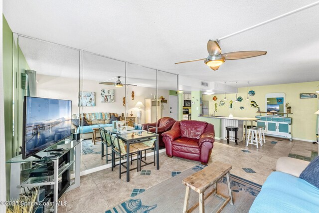 4800 Ocean Beach Blvd Unit 218, Cocoa Beach, FL 32931 - living area featuring ceiling fan, tile patterned floors, and a textured ceiling