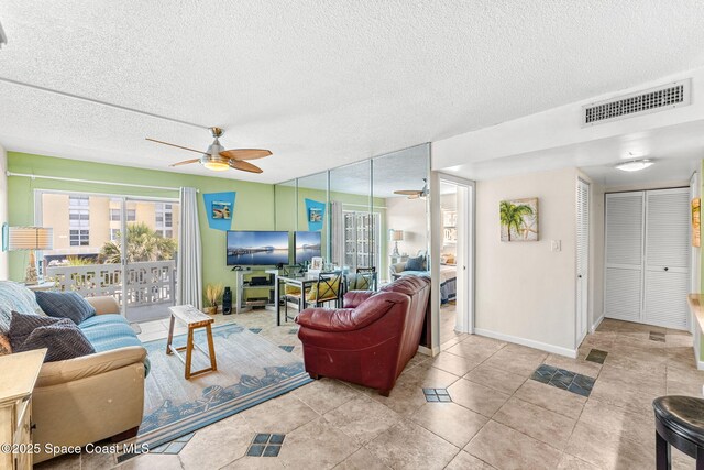 4800 Ocean Beach Blvd Unit 218, Cocoa Beach, FL 32931 - tiled living room with ceiling fan, a textured ceiling, and healthy amount of natural light