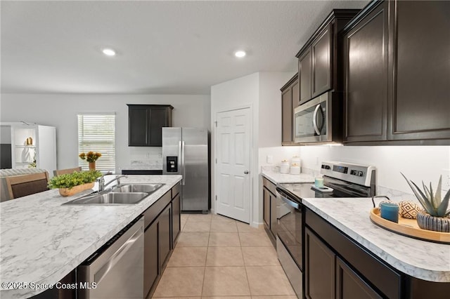1093 Wabash Rd SE, Palm Bay, FL 32909 - kitchen with stainless steel appliances, a sink, light countertops, light tile patterned floors, and open floor plan