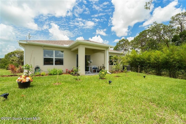 1093 Wabash Rd SE, Palm Bay, FL 32909 - back of house featuring stucco siding, a yard, and a patio area