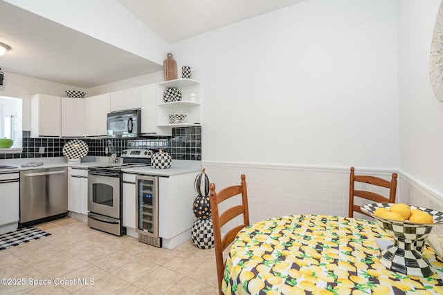 914 S Fork Cir, Melbourne, FL 32901 - kitchen with stainless steel appliances, beverage cooler, light countertops, white cabinetry, and open shelves