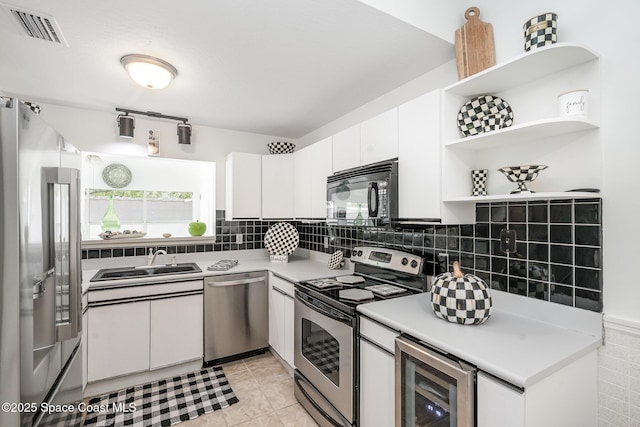 914 S Fork Cir, Melbourne, FL 32901 - kitchen featuring appliances with stainless steel finishes, beverage cooler, open shelves, and white cabinets
