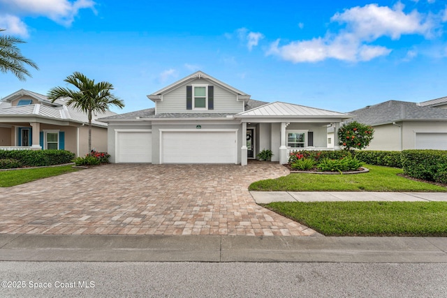 1649 Tullagee Ave, Melbourne, FL 32940 - traditional home with a standing seam roof, decorative driveway, a front lawn, stucco siding, and a metal roof