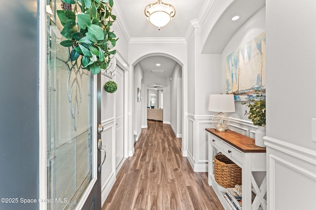 1649 Tullagee Ave, Melbourne, FL 32940 - corridor featuring arched walkways, crown molding, wood finished floors, and a wainscoted wall