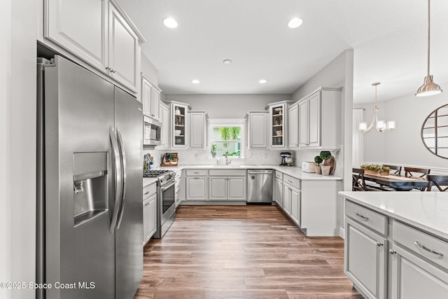 1649 Tullagee Ave, Melbourne, FL 32940 - kitchen featuring stainless steel appliances, decorative backsplash, recessed lighting, light countertops, and wood finished floors