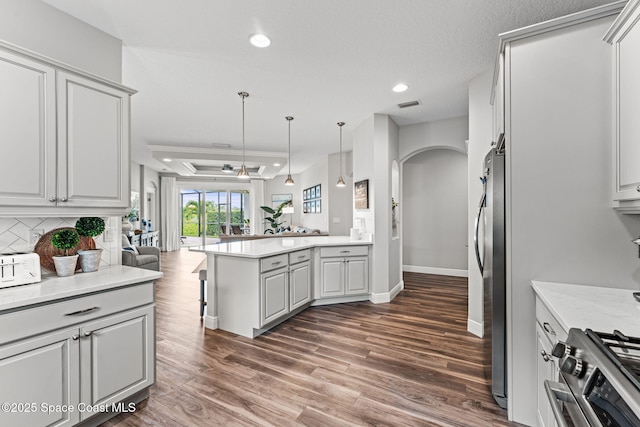 1649 Tullagee Ave, Melbourne, FL 32940 - kitchen with open floor plan, stainless steel appliances, a peninsula, arched walkways, and wood finished floors