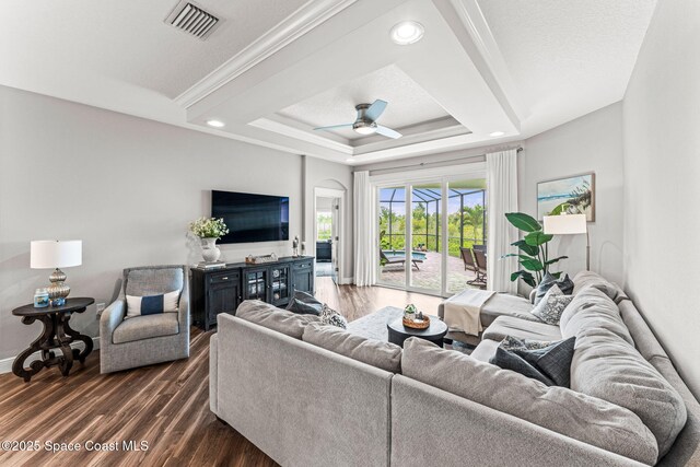 1649 Tullagee Ave, Melbourne, FL 32940 - living area with dark wood-style flooring, a raised ceiling, a ceiling fan, ornamental molding, and recessed lighting