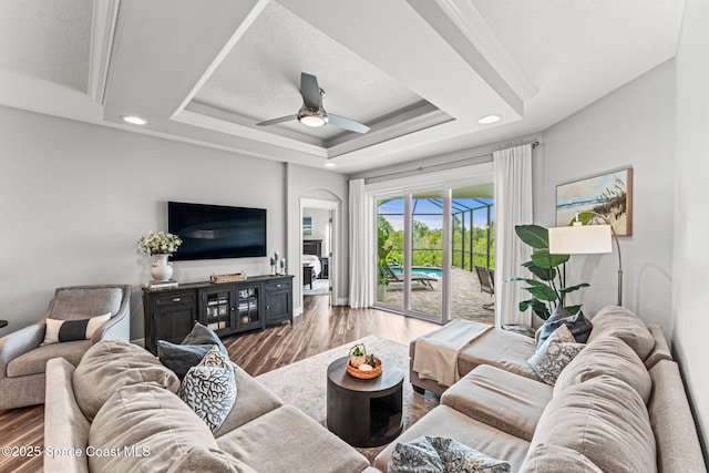 1649 Tullagee Ave, Melbourne, FL 32940 - living room with ceiling fan, wood finished floors, arched walkways, recessed lighting, and a raised ceiling