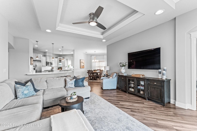 1649 Tullagee Ave, Melbourne, FL 32940 - living room featuring recessed lighting, ceiling fan, wood finished floors, a tray ceiling, and crown molding