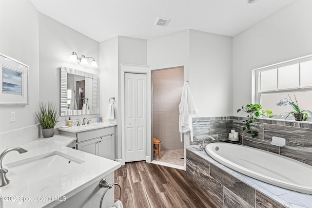 1649 Tullagee Ave, Melbourne, FL 32940 - bathroom with vanity, a garden tub, wood finished floors, and a tile shower