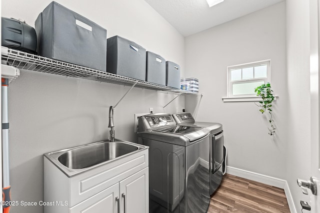 1649 Tullagee Ave, Melbourne, FL 32940 - washroom featuring washing machine and clothes dryer, cabinet space, and wood finished floors