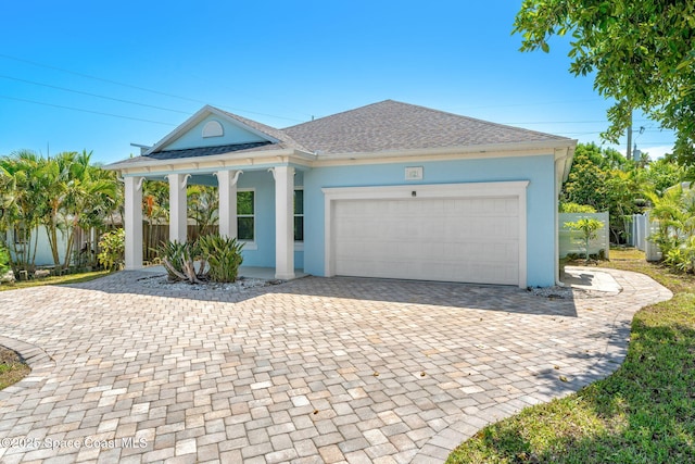 1121 S Orlando Ave, Cocoa Beach, FL 32931 - view of front of property featuring stucco siding, decorative driveway, an attached garage, a porch, and roof with shingles
