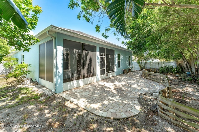 1121 S Orlando Ave, Cocoa Beach, FL 32931 - back of property with a sunroom, a fenced backyard, and a patio