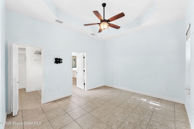 1121 S Orlando Ave, Cocoa Beach, FL 32931 - unfurnished bedroom featuring light tile patterned floors, a spacious closet, a closet, and a raised ceiling