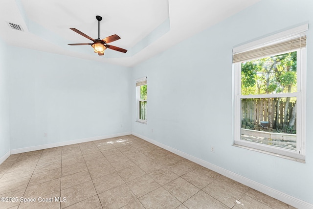 1121 S Orlando Ave, Cocoa Beach, FL 32931 - empty room with ceiling fan, light tile patterned flooring, and a raised ceiling