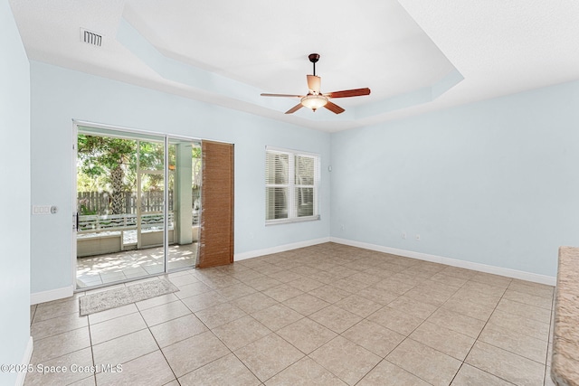 1121 S Orlando Ave, Cocoa Beach, FL 32931 - empty room with a tray ceiling, ceiling fan, and light tile patterned floors
