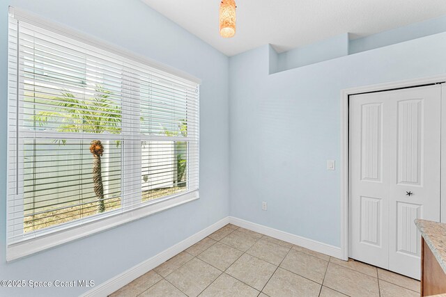 1121 S Orlando Ave, Cocoa Beach, FL 32931 - spare room featuring healthy amount of natural light and light tile patterned flooring