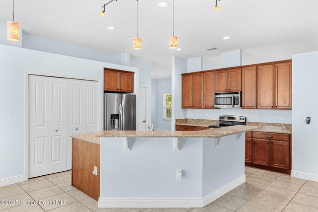 1121 S Orlando Ave, Cocoa Beach, FL 32931 - kitchen featuring stainless steel appliances, brown cabinetry, light tile patterned flooring, a kitchen breakfast bar, and recessed lighting
