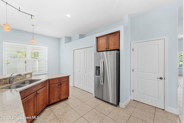 1121 S Orlando Ave, Cocoa Beach, FL 32931 - kitchen featuring stainless steel fridge with ice dispenser, brown cabinets, decorative light fixtures, and light tile patterned floors