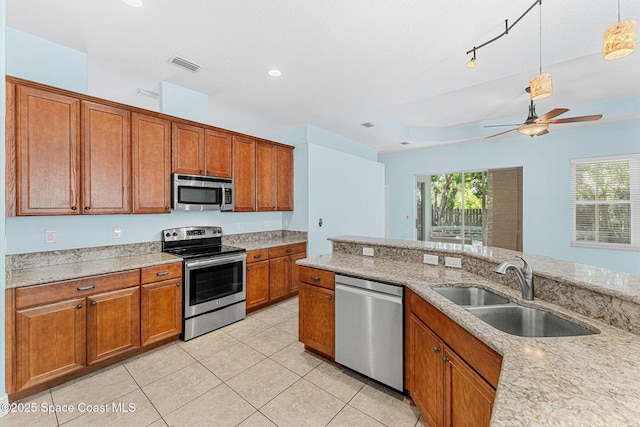 1121 S Orlando Ave, Cocoa Beach, FL 32931 - kitchen featuring appliances with stainless steel finishes, brown cabinetry, ceiling fan, decorative light fixtures, and recessed lighting