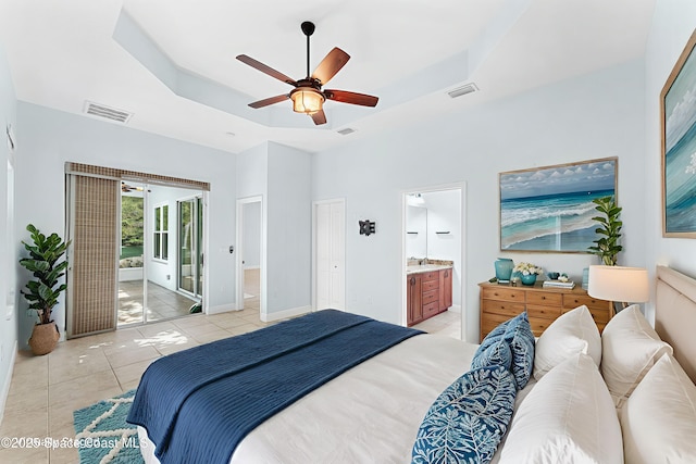 1121 S Orlando Ave, Cocoa Beach, FL 32931 - bedroom with a tray ceiling, access to outside, light tile patterned flooring, ensuite bath, and a ceiling fan