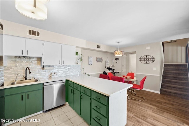 1020 Abada Ct NE Unit 108, Palm Bay, FL 32905 - kitchen with dishwasher, a peninsula, light countertops, white cabinets, and decorative backsplash