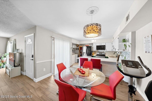 1020 Abada Ct NE Unit 108, Palm Bay, FL 32905 - dining room with light wood-style flooring and washing machine and dryer