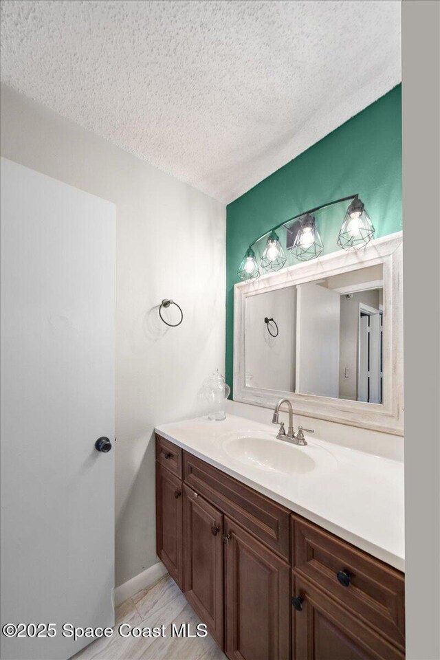 1020 Abada Ct NE Unit 108, Palm Bay, FL 32905 - bathroom featuring a textured ceiling and vanity