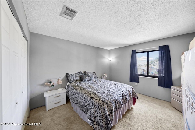 1020 Abada Ct NE Unit 108, Palm Bay, FL 32905 - bedroom featuring light colored carpet, a closet, and a textured ceiling