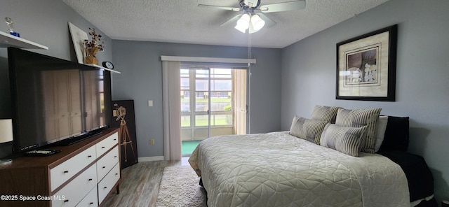 2135 N Courtenay Pkwy Unit 104, Merritt Island, FL 32953 - bedroom featuring a textured ceiling, light wood-type flooring, and a ceiling fan