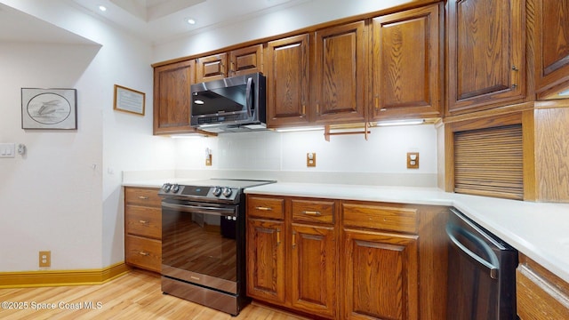 905 N Harbor City Blvd Unit 403, Melbourne, FL 32935 - kitchen with stainless steel appliances, light countertops, light wood finished floors, brown cabinets, and recessed lighting