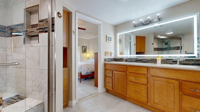 905 N Harbor City Blvd Unit 403, Melbourne, FL 32935 - ensuite bathroom featuring a stall shower, double vanity, tile patterned flooring, tasteful backsplash, and ceiling fan