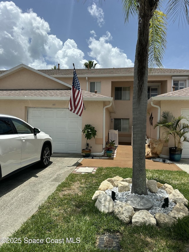 111 Plover Ln Unit 3-35, Rockledge, FL 32955 - view of front of house with a garage, stucco siding, and concrete driveway