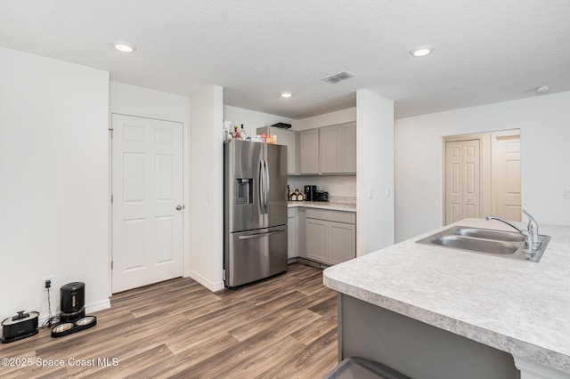 788 Isar Ave NW, Palm Bay, FL 32907 - kitchen with stainless steel fridge, gray cabinets, wood finished floors, light countertops, and recessed lighting