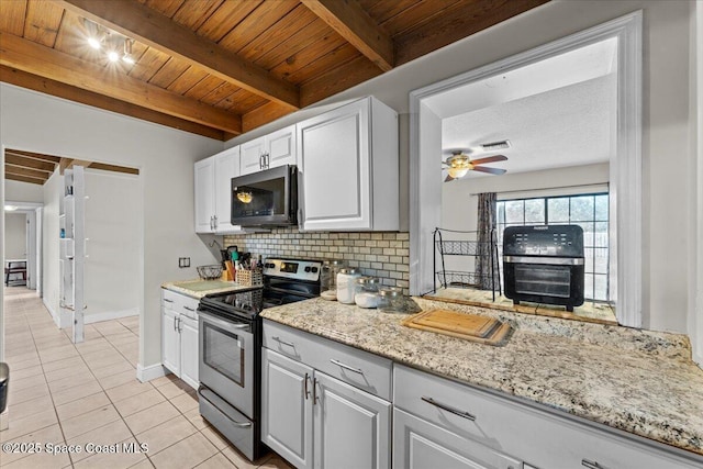 1636 Dixie Way, Melbourne, FL 32935 - kitchen featuring stainless steel appliances, a wood ceiling with exposed beams, decorative backsplash, light tile patterned floors, and a wood stove