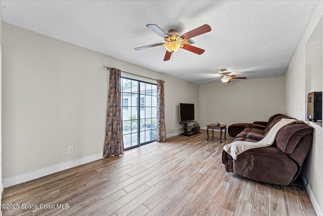 1636 Dixie Way, Melbourne, FL 32935 - living room featuring ceiling fan, light wood finished floors, and a textured ceiling
