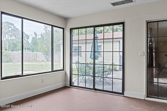 1636 Dixie Way, Melbourne, FL 32935 - spare room featuring plenty of natural light, finished concrete flooring, and a textured ceiling