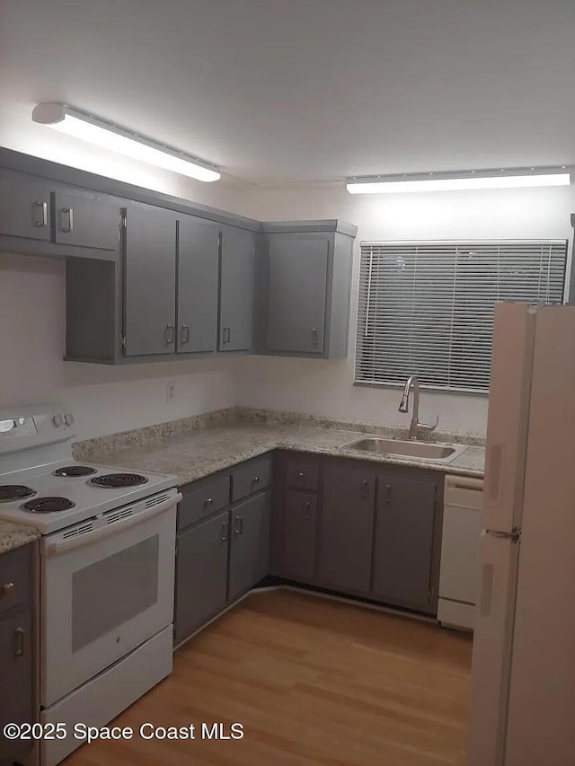 7770 Tahiti Ln Unit 208, Lake Worth, FL 33467 - kitchen with white appliances, gray cabinets, light wood-style floors, and light countertops