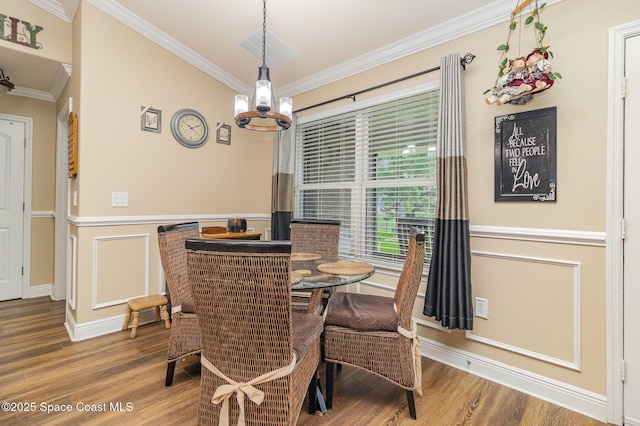 231 Nardo Ave SW, Palm Bay, FL 32908 - dining space with ornamental molding, wood finished floors, a wainscoted wall, a chandelier, and a decorative wall