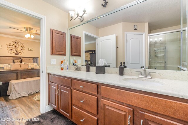 231 Nardo Ave SW, Palm Bay, FL 32908 - full bath with double vanity, a ceiling fan, wood finished floors, a shower stall, and ornamental molding