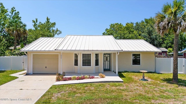 5510 Holden Rd, Cocoa, FL 32927 - view of front of house featuring a standing seam roof, an attached garage, concrete driveway, covered porch, and a metal roof