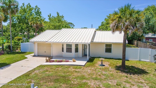 5510 Holden Rd, Cocoa, FL 32927 - view of front of home featuring a garage, driveway, a standing seam roof, a metal roof, and covered porch