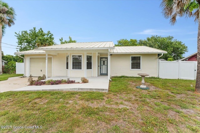 5510 Holden Rd, Cocoa, FL 32927 - ranch-style house with an attached garage, concrete driveway, covered porch, and a metal roof