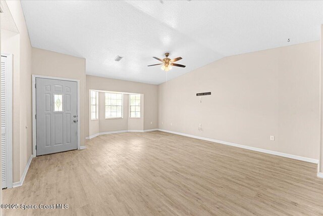 5510 Holden Rd, Cocoa, FL 32927 - unfurnished living room featuring ceiling fan, light wood-style flooring, and vaulted ceiling