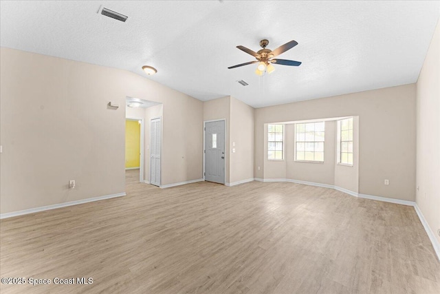5510 Holden Rd, Cocoa, FL 32927 - empty room featuring ceiling fan, light wood-type flooring, vaulted ceiling, and a textured ceiling