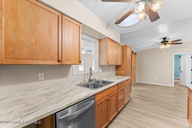 5510 Holden Rd, Cocoa, FL 32927 - kitchen with stainless steel dishwasher, ceiling fan, a textured ceiling, light countertops, and light wood-style floors