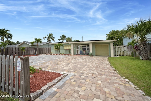 1030 S Orlando Ave, Cocoa Beach, FL 32931 - view of front of home featuring decorative driveway, roof mounted solar panels, and an attached garage