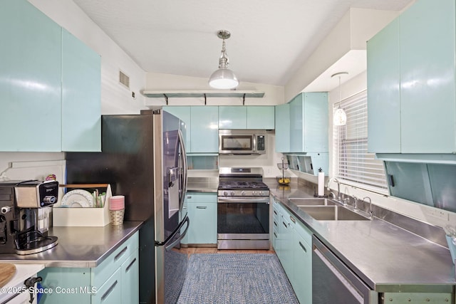 1030 S Orlando Ave, Cocoa Beach, FL 32931 - kitchen with stainless steel countertops, stainless steel appliances, decorative light fixtures, lofted ceiling, and blue cabinetry