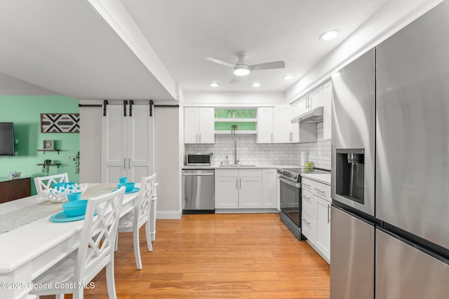 1710 Atlantic St Unit 5E, Melbourne Beach, FL 32951 - kitchen featuring stainless steel appliances, ceiling fan, white cabinetry, decorative backsplash, and recessed lighting