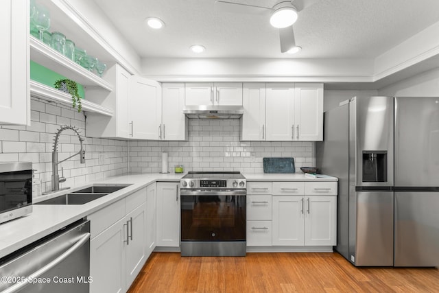 1710 Atlantic St Unit 5E, Melbourne Beach, FL 32951 - kitchen featuring appliances with stainless steel finishes, light countertops, open shelves, white cabinets, and a textured ceiling